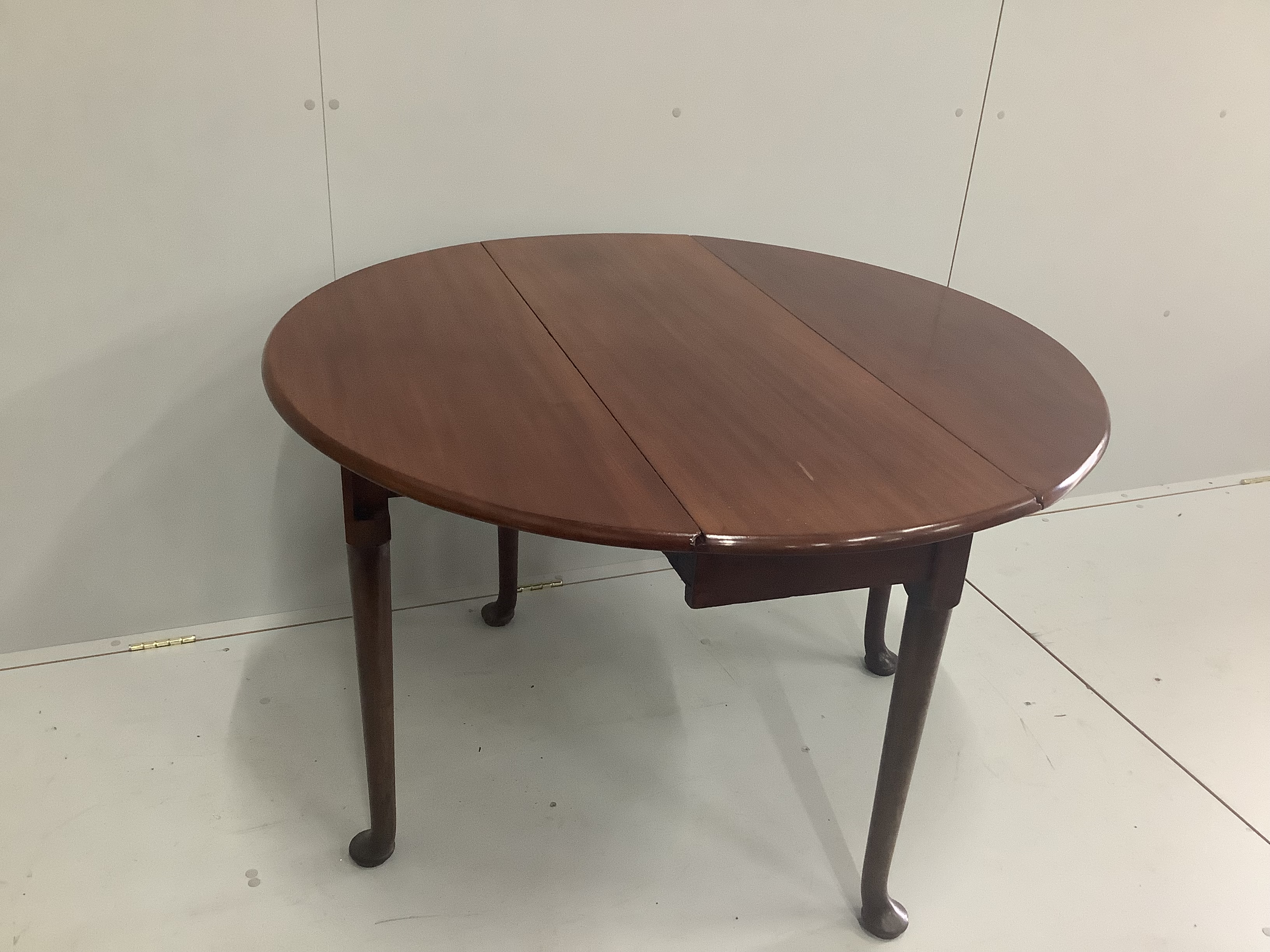 A George III mahogany oval pad foot drop leaf dining table, width 106cm, depth 110cm extended, height 71cm
